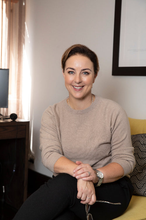Professional headshot of Rachel Brace seated in office, smiling, facing camera