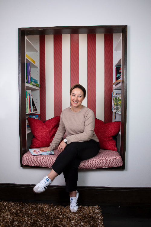 Author and psychologist Rachel Brace in office reading nook with hand on her children's picture books