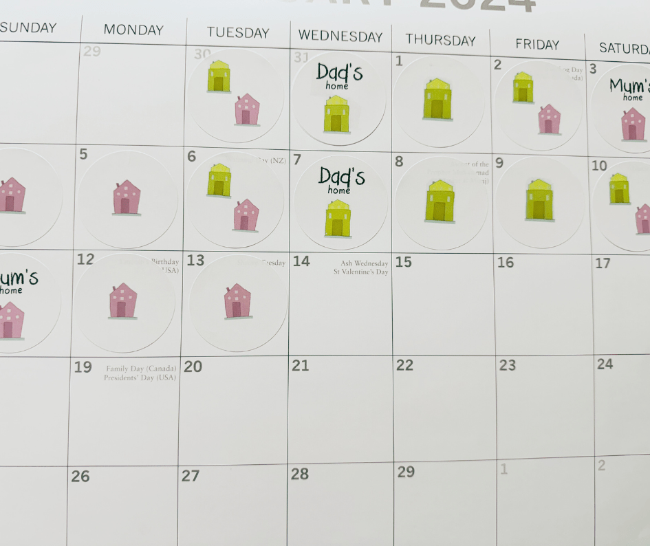 photo of wall calendar page with yellow and pink stickers depicting parenting schedule